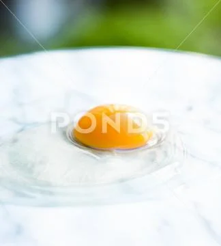 Egg yolk on marble - recipe ingredients and homemade cooking concept Stock Photos