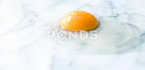 Egg yolk on marble - recipe ingredients and homemade cooking concept Stock Photos