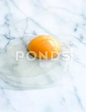 Egg yolk on marble - recipe ingredients and homemade cooking concept Stock Photos