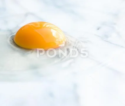 Egg yolk on marble - recipe ingredients and homemade cooking concept Stock Photos