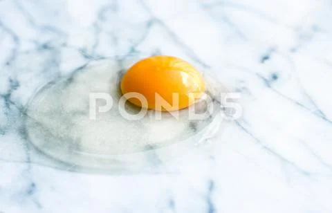 Egg yolk on marble - recipe ingredients and homemade cooking concept Stock Photos