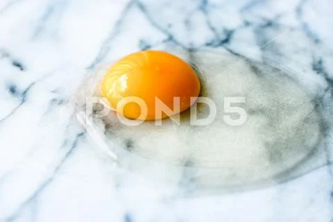 Egg yolk on marble - recipe ingredients and homemade cooking concept Stock Photos