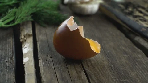 Egg yolk in the shell slowly spinning on the breakfast table 動画素材 104981676
