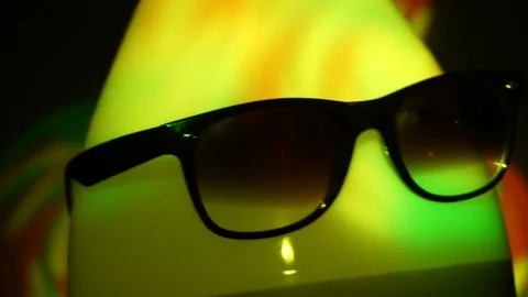 Egghead man in sunglasses in the multicolored spotlight Stock Footage 72541996