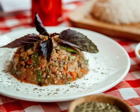 Eggplant caviar served with basil Stock Photos