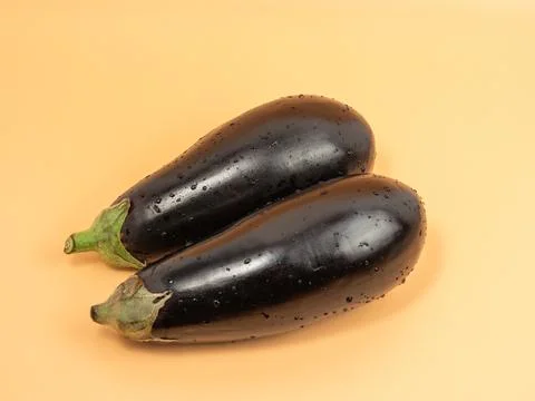 Eggplant on an orange background. Stock Photos