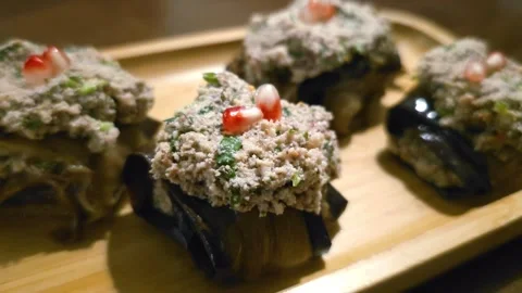 Eggplant rolls topped with walnut paste and garnished with pomegranate seeds Stock Footage 283404167