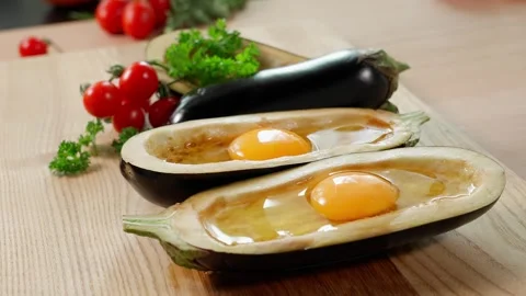 Eggplants in the shape of boats in the middle of an egg, on a wooden board Stock Footage 270150413