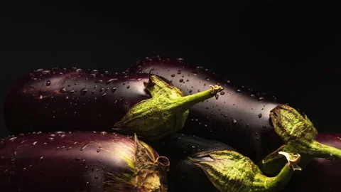 Eggplants spinning around their axis on black background Stock Footage 138329315