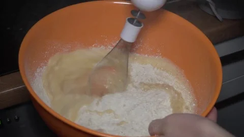 Eggs and flour being mixed with a mixer in a bowl Stock Footage 84198079