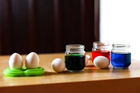 Eggs and jars with paint for easter decoration on the table Stock Photos