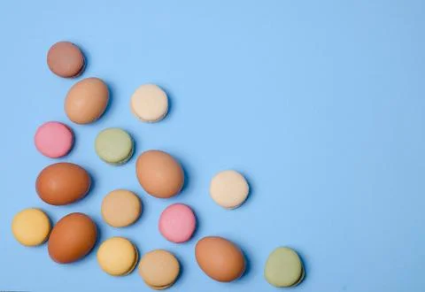 Eggs and macaroons Easter theme in pastel colors on blue background. Foto stock