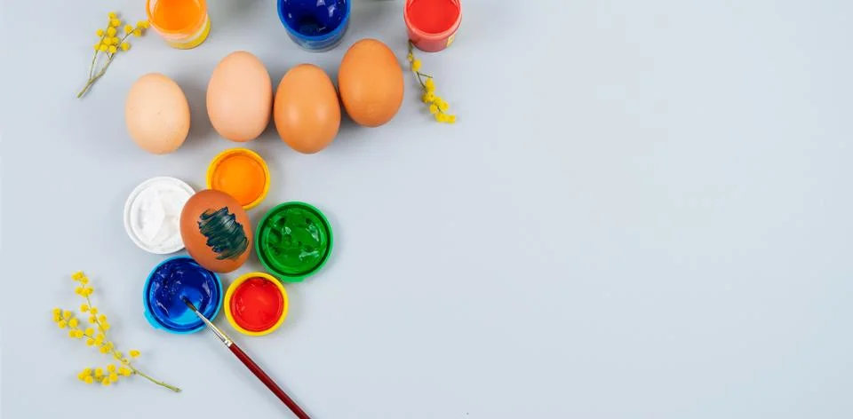 Eggs and paints. Easter eggs decoration process. Copy space. Top view. Stock Photos