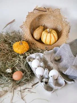 Eggs and quail eggs in a package, pumpkins ,  hay, Easter concept Stock Photos