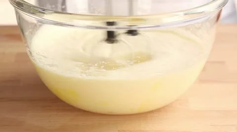 Eggs and sugar being mixed with an electric whisk Stock Footage 24657143