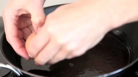 Eggs are given into pan to make fried eggs Stock Footage 99727229