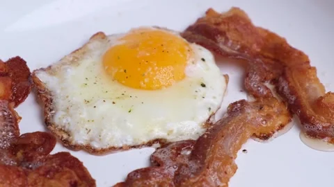 Eggs with bacon are fried in a frying pan close-up Stock Footage 276293590