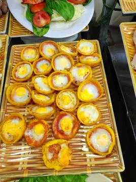 Eggs baked in small crispy cups are arranged on a tray at a food stall in a.. Stock Photos