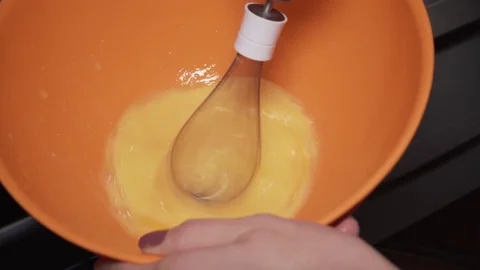 Eggs being scrambled with a mixer in a bowl Stock Footage 84197712