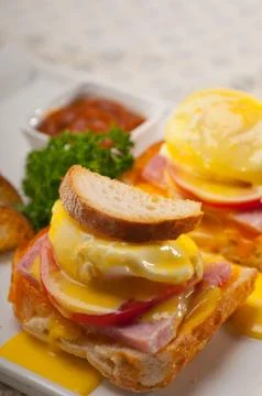 Eggs benedict on bread with tomato and ham Stock Photos