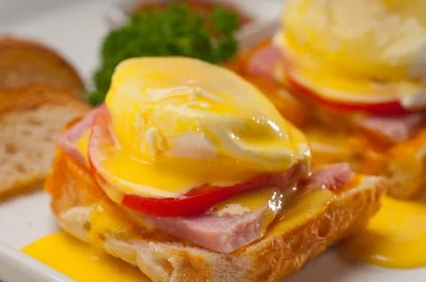 Eggs benedict on bread with tomato and ham Stock Photos