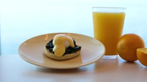 Eggs Benedict Healthy breakfast with fresh fruits, eggs, orange juice, and whole Stock Footage 317711812