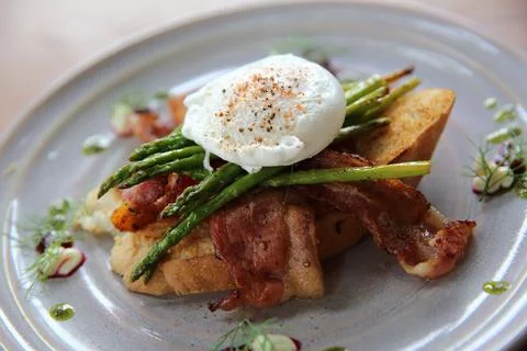 Eggs benedict poached egg on bacon asparagus and bread breakfast Stock Photos