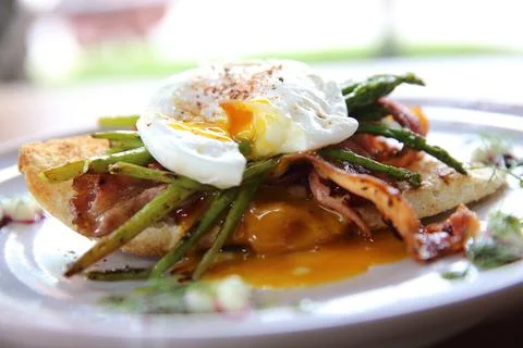 Eggs benedict poached egg on bacon asparagus and bread breakfast Stock Photos