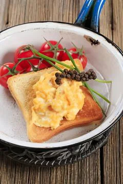 Eggs benedict toast with cherry tomatoes and capers Stock Photos