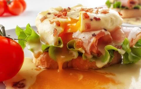 Eggs Benedict on toasted muffins with ham and sauce Stock Photos