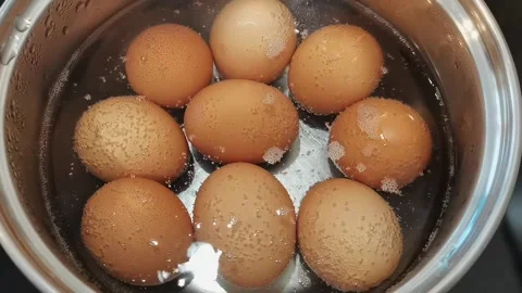 Eggs boiling in water, close up. Video stock 163865392