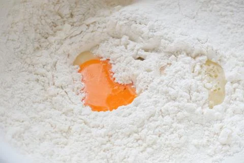 Eggs in the bowl of flour Stock Photos
