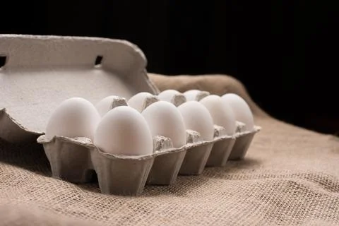 Eggs in box on fabric texture Stock Photos