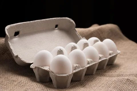 Eggs in box on fabric texture Stock Photos