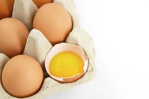 Eggs in a cardboard box on a white background. Copy space. Stock Photos