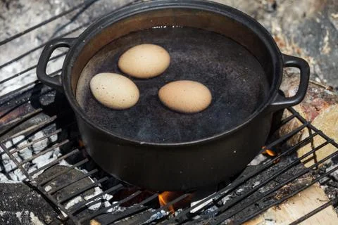 Eggs in a Cast Cauldron full Boiling Water Stock-Fotos