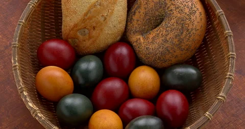 Eggs colored in organic dyes and buns in a wicker bowl. Stock Footage 330134698