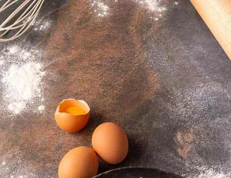 Eggs on a dark kitchen counter with a cracked shell Fotos Stock