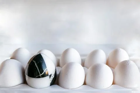 Eggs of different colors in cardboard boxes. marble stone egg on a background Stock Photos
