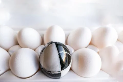 Eggs of different colors in cardboard boxes. marble stone egg on a background Stock Photos