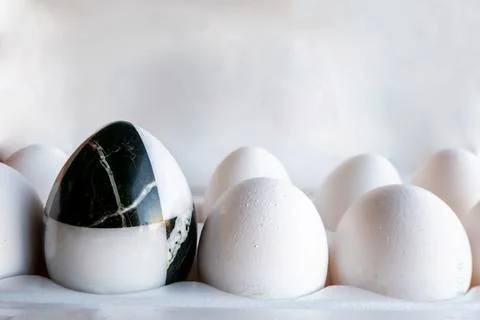 Eggs of different colors in cardboard boxes. marble stone egg on a background Stock Photos