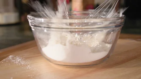 Eggs dropping into bowl of flour for cake batter Stock Footage 304187309