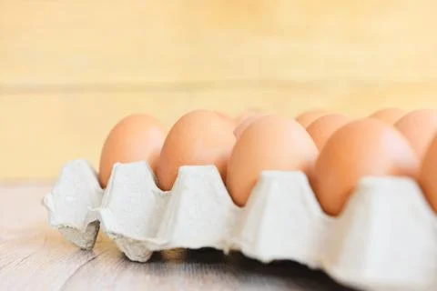 Eggs in egg box on wooden background / Close up of raw chicken eggs organic.. Foto stock