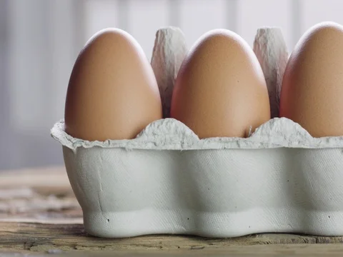 Eggs in egg carton in a brightly lit kitchen - track left to right 스톡 동영상 75996554
