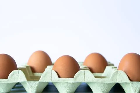Eggs on a egg carton separated with depth of field on a white background. Soc Stock Photos