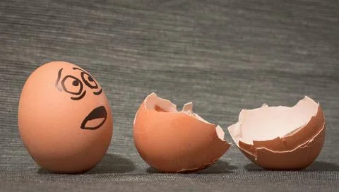 Eggs Faces drawnigs. Egg staring with dramatic expression at empty eggschell Stock Photos