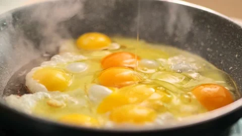 Eggs fall into the frying pan. process of preparing breakfast. Stock Footage 234907552