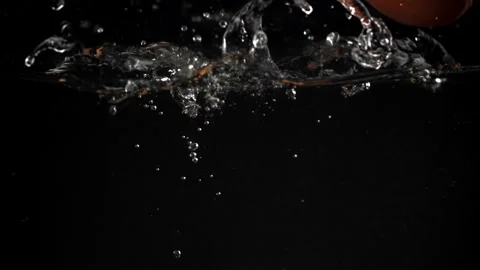Eggs falling under water on a black background. Filmed on a high-speed camera at Stock Footage 322809727