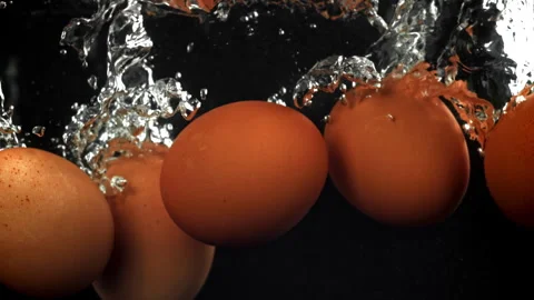 Eggs falling under water on a black background. Filmed on a high-speed camera at Stock Footage 322832911