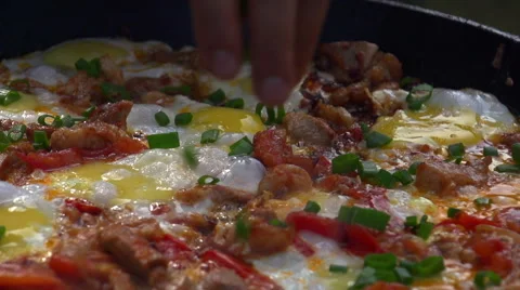 The eggs fried in a griddle and sprinkled finely chopped onions. Close up view Stock Footage 54912201